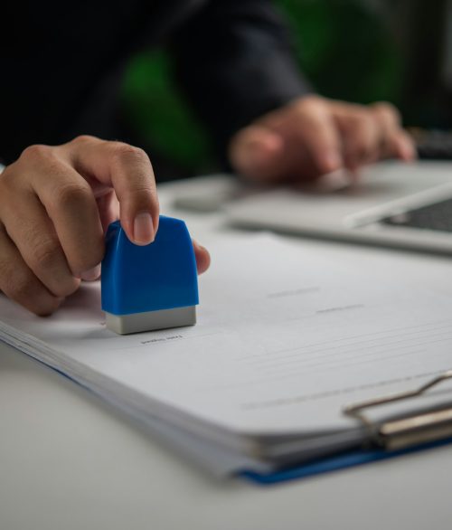 Hand stamping approval on an official document, workflow concept. Hand stamping approval on an official document, workflow concept.